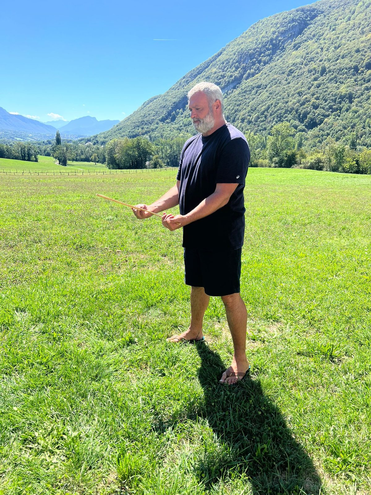 Alexis Lenne utilisant des baguettes de sourcier sur le terrain